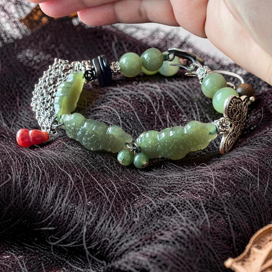 Green jade hand carved sakura flower bracelet with carnelian hulu charm on dark mesh fabric
