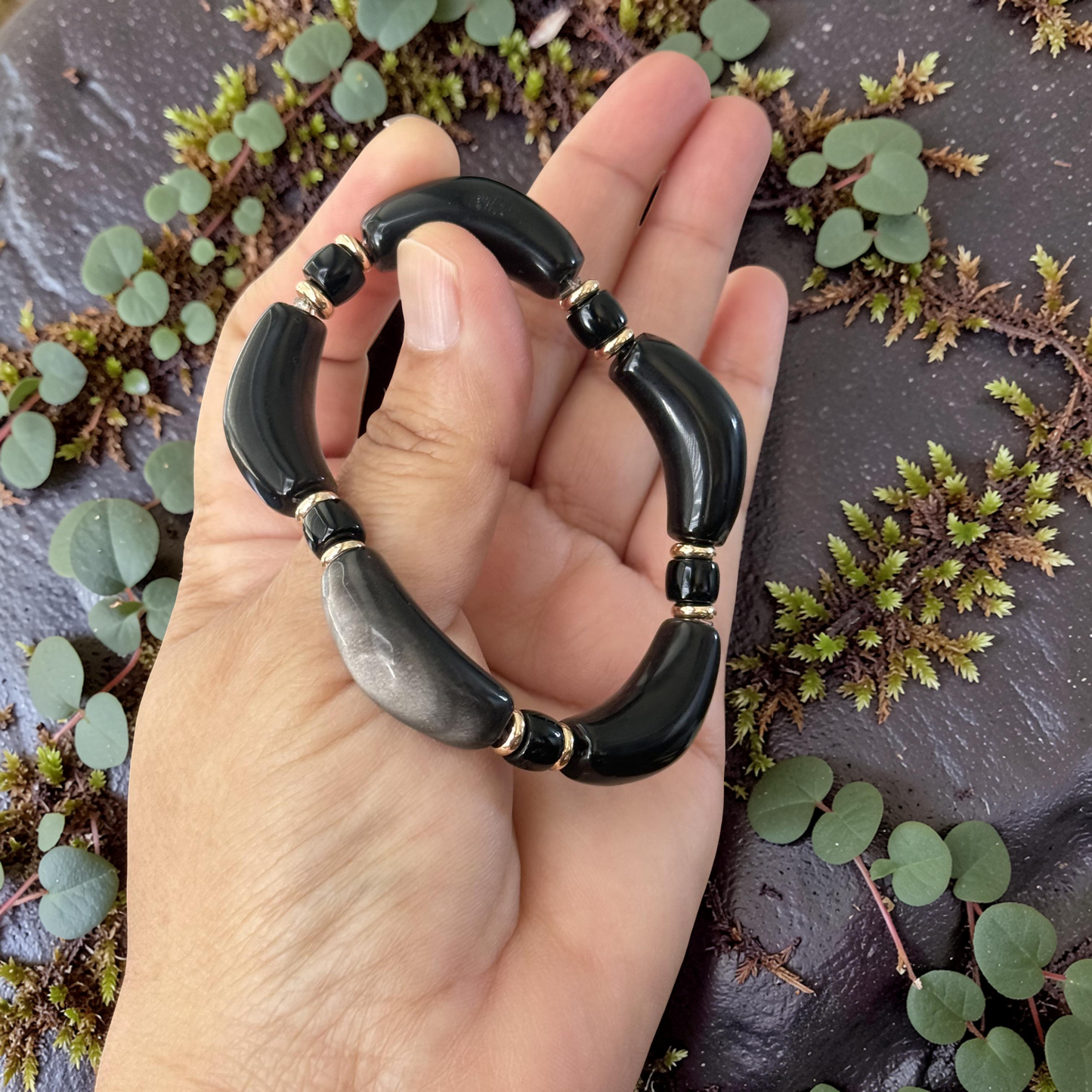 Silver Obsidian Bracelet on outdoor rock with pebbles