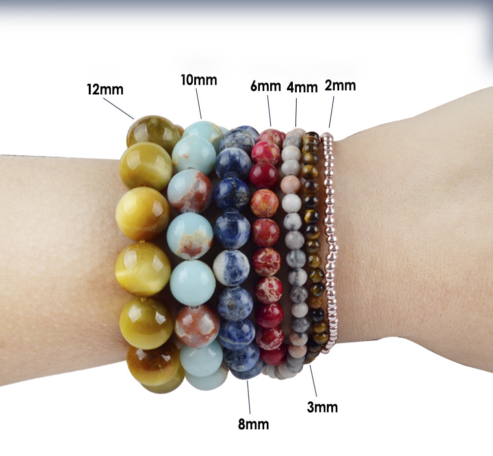 Stack of colorful beaded bracelets on a wrist with size labels.