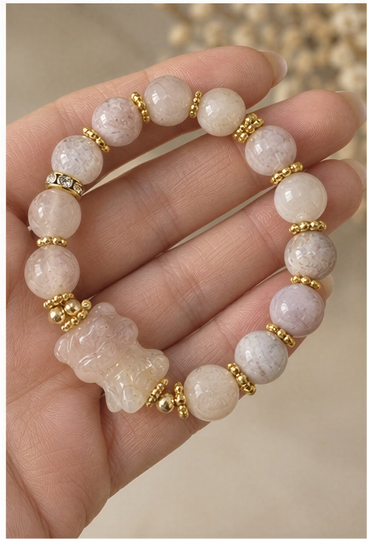 Sakura Agate carved bear bracelet displayed in an open cream-colored box.