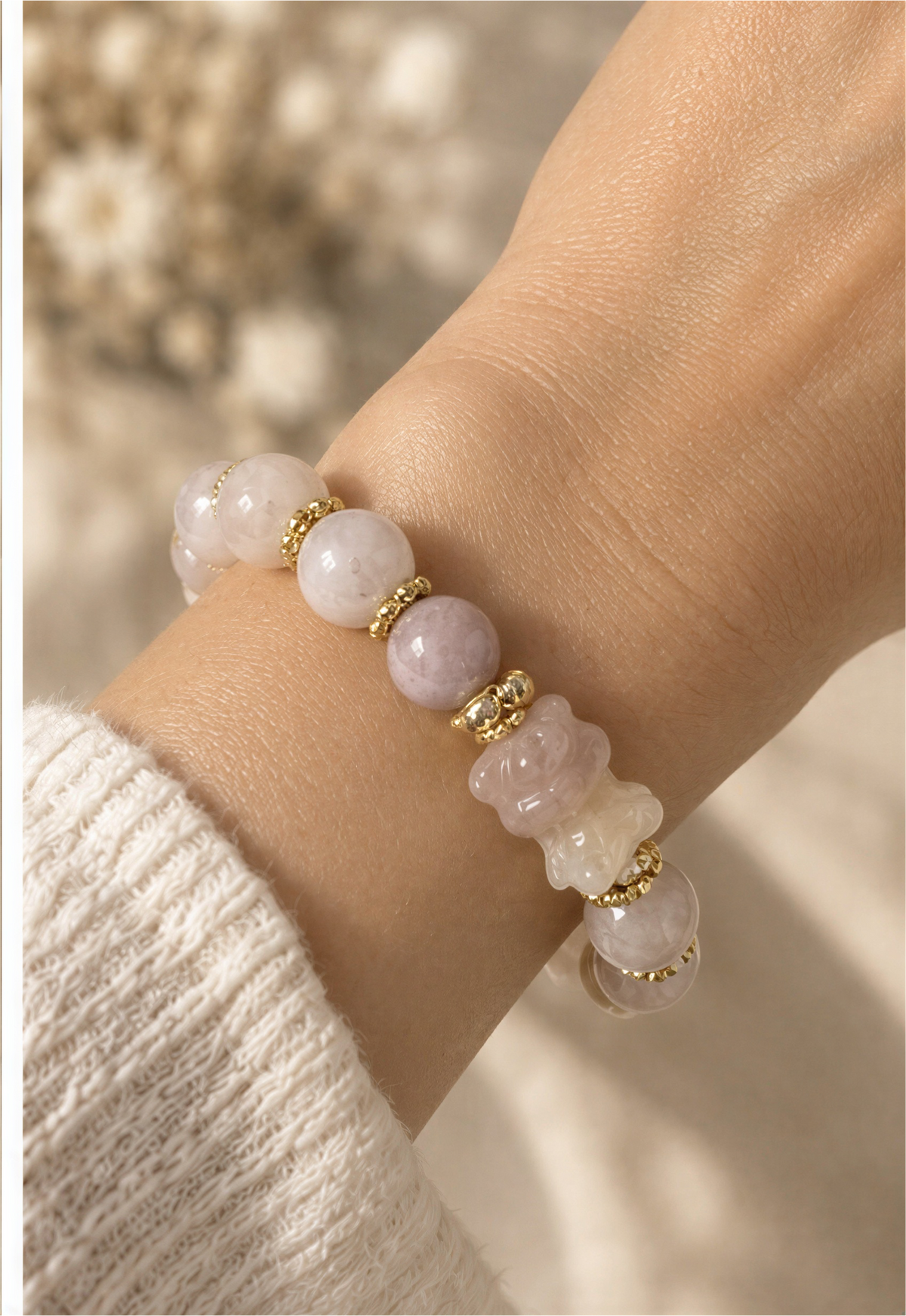 Close-up of Sakura Agate bear carving, cloudy round beads, gold-tone spacers and sparkling accent ring.