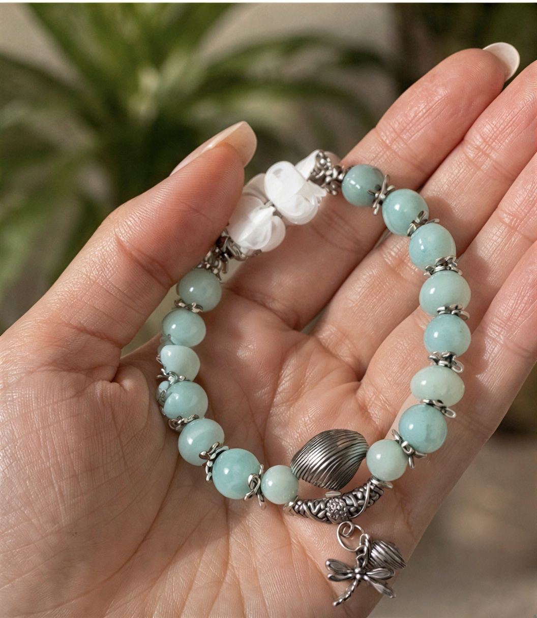 Model wearing a pale aqua Larimar bracelet with silver-tone dragonfly charm and white blouse.