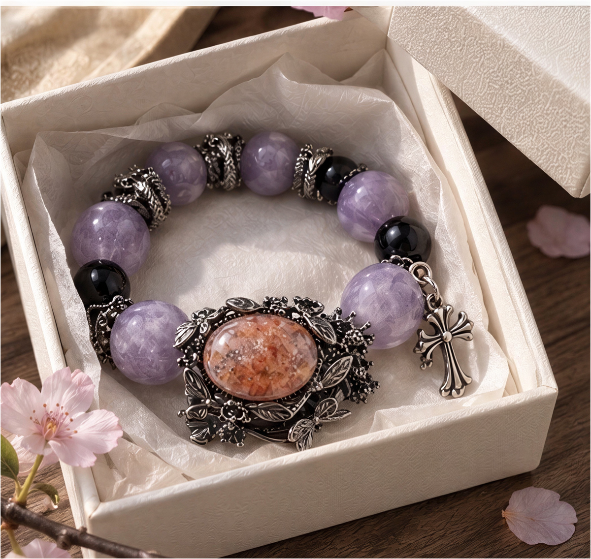 Amethyst and Fire Quartz statement bracelet worn on a wrist, showing botanical setting and cross charm.