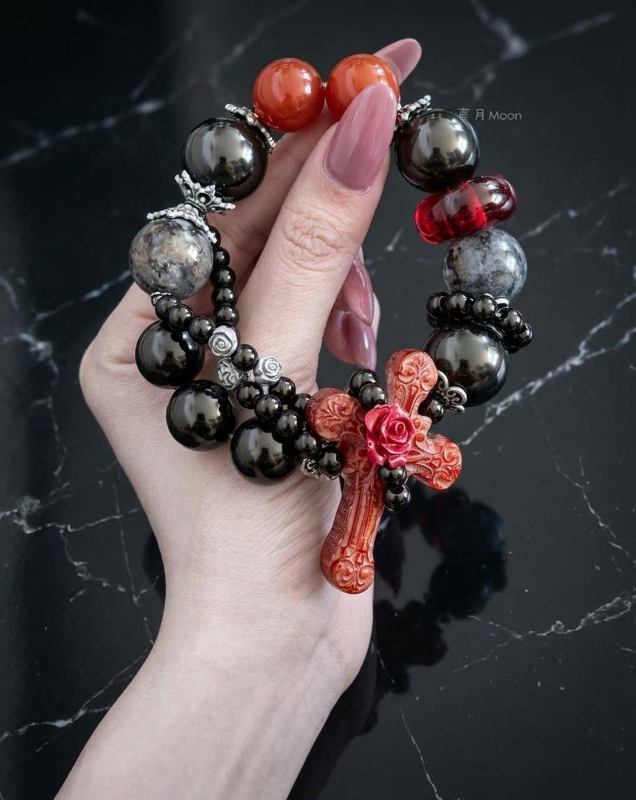 Carnelian cross and gray moonstone beaded bracelet flat lay on velvet