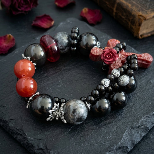 Carnelian cross bracelet held in hand showing cross pendant detail