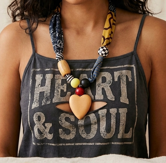 Person wearing a tank top with 'Heart & Soul' text and a colorful scarf necklace.