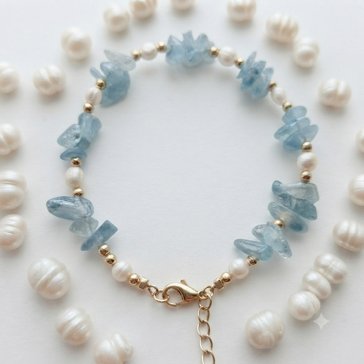Aquamarine chip and freshwater pearl bracelet styled on blue linen with crystal accents