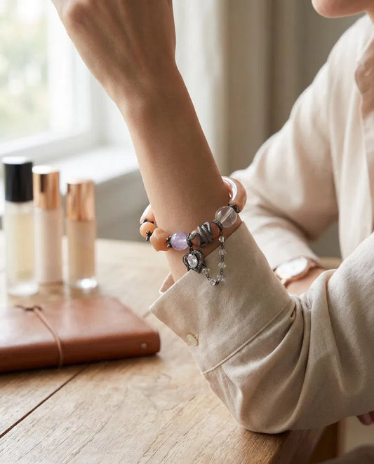 Close-up of lavender amethyst bead, coiled snake accent and sparkling heart charm on bangle