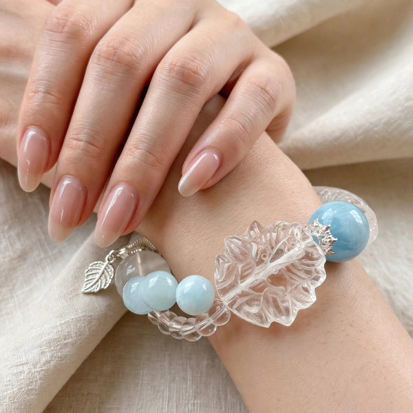 Clear quartz and aquamarine bangle bracelet with a carved clear quartz focal detail, transparent bead accents, and pale blue stones.