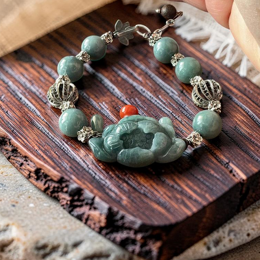 Hand carved jade lotus bracelet with silver crown spacers displayed on rustic wood surface
