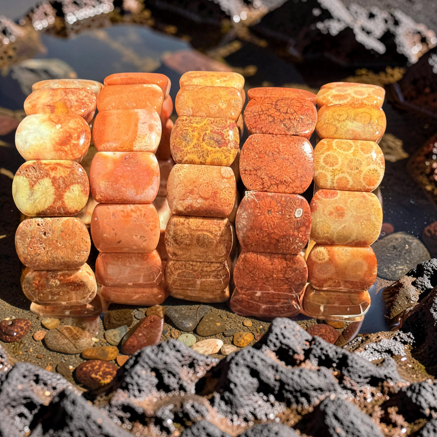 Stack of polished orange and brown coral jade on a natural rock background