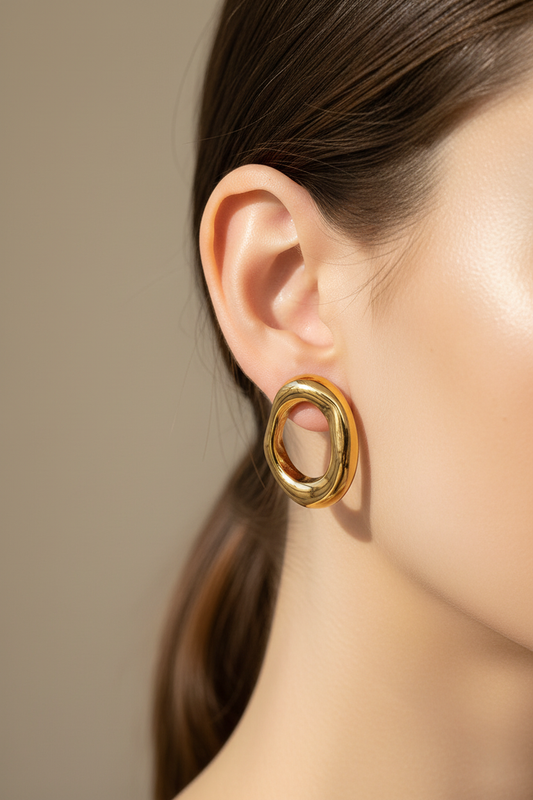 Model wearing gold oval hoop stud earrings